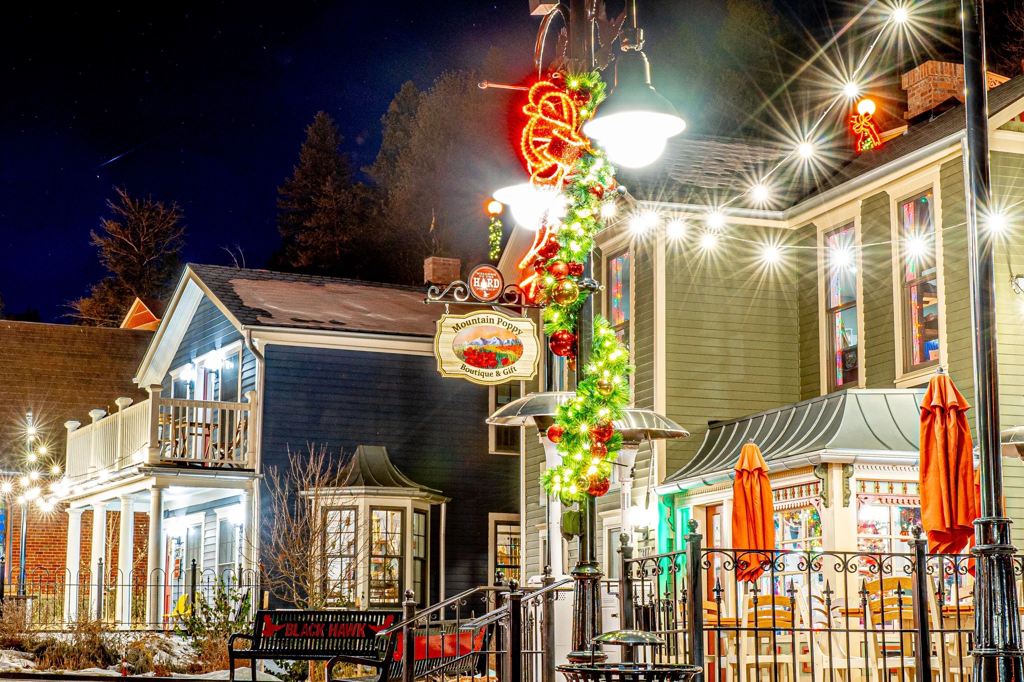 Festive holiday decorations brighten a charming downtown shopping area at night.