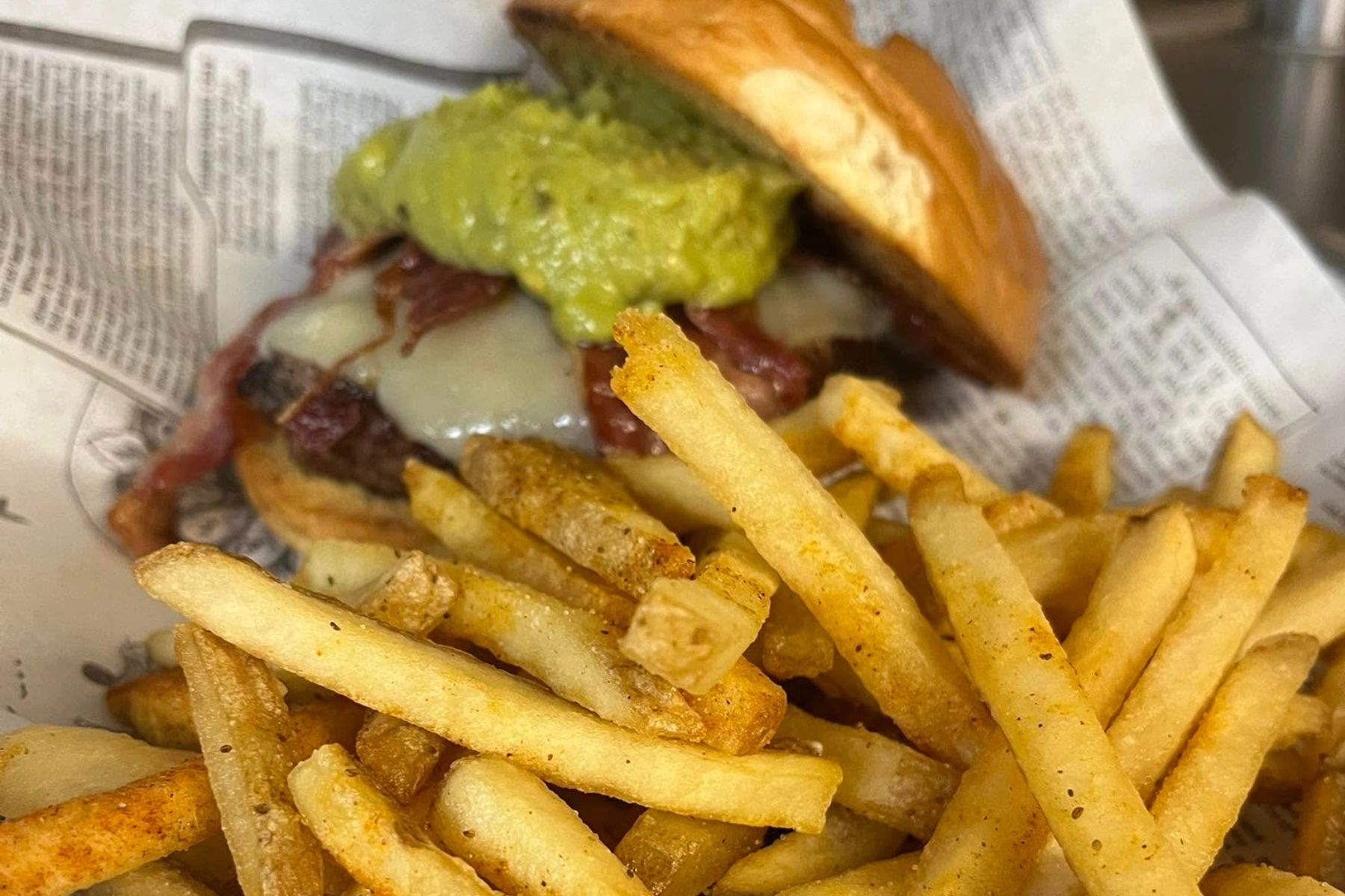 Loaded burger with guacamole and fries.