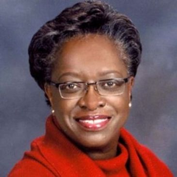 Woman wearing eyeglass with red suit and looking on the camera