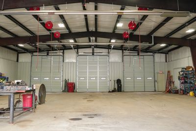Spacious industrial garage with multiple doors and tools.