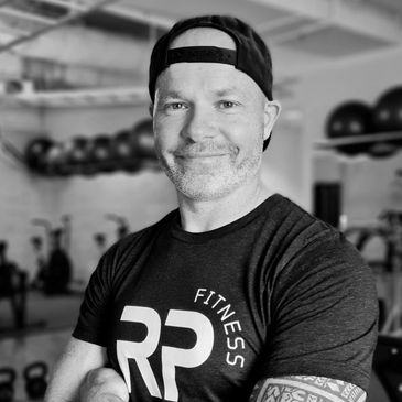 Confident man in gym wearing a fitness t-shirt and backward cap.