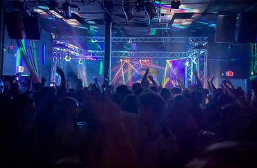 Crowd enjoying a live concert with colorful stage lights.