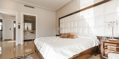 Bright modern bedroom with a large bed and elegant decor.