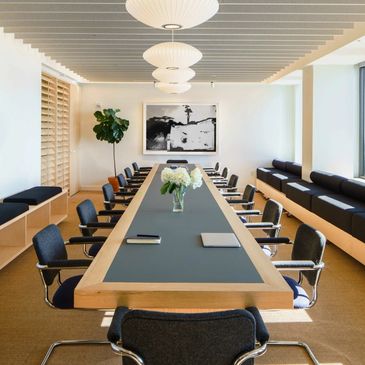 Modern conference room with long table and city view.