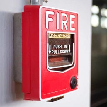 Red fire alarm on a wall.