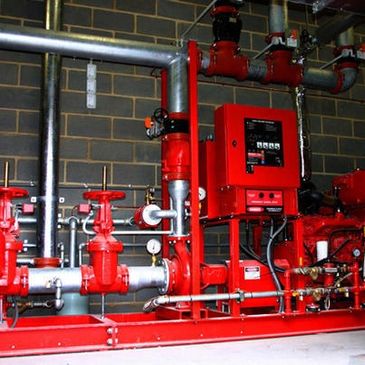 Red industrial machinery with pipes and valves.