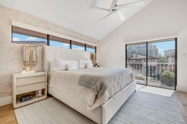 Bright modern bedroom with large windows and sliding door.