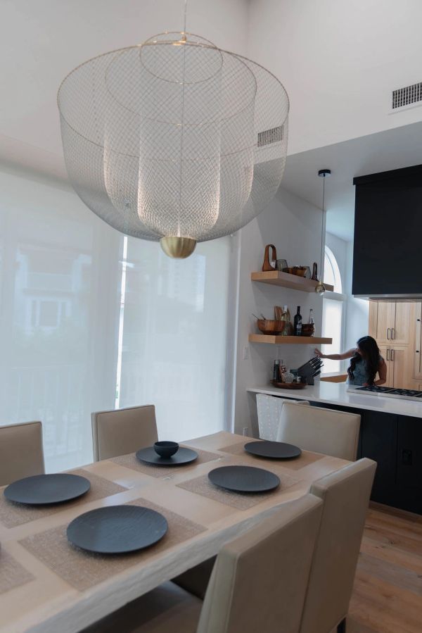 Modern dining area with a large pendant light and elegant table setting.
