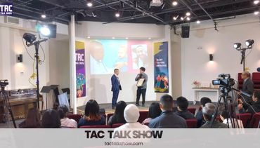 Two men speaking on stage during a TAC Talk Show event.