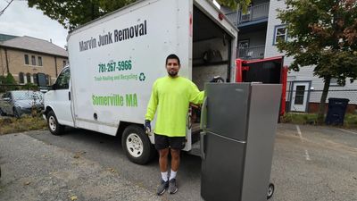 Marvin Junk Removal owner hauling appliance from a Cambridge, MA walk-up apartment —same-day service