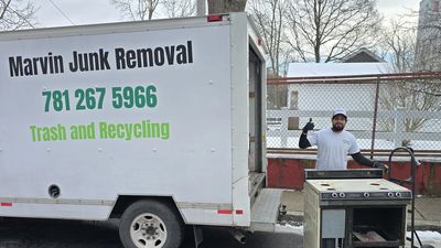 Marvin Junk Removal owner hauling cast iron radiator from a Somerville, MA triple-decker basement 