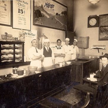 Vintage diner scene with staff and patrons from early 20th century.