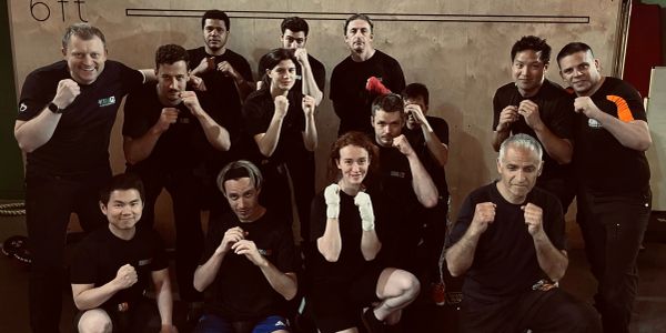 Group posing with fists up in martial arts or boxing stance.