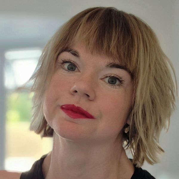 Woman with short blonde hair and red lipstick.