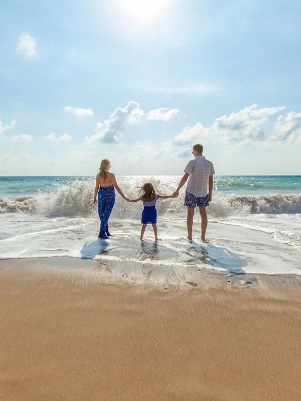 People walking on the beach holding hands.