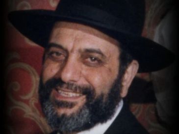 Smiling man with beard and black hat.