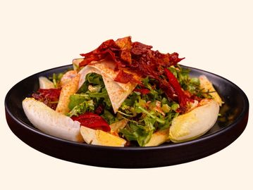 Fresh salad with crispy bacon and boiled eggs on a black plate.
