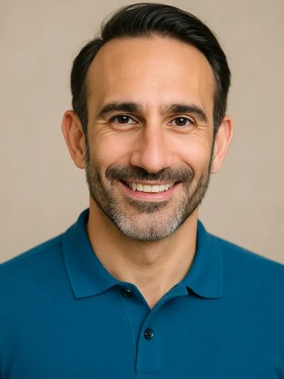 A man smiling with wearing blue T shirt and looking ahead
