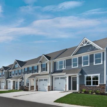 Row of modern suburban townhouses under a clear blue sky.
