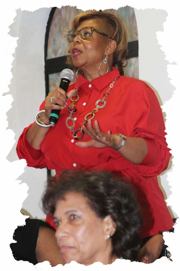 Woman in red shirt speaking with a microphone.