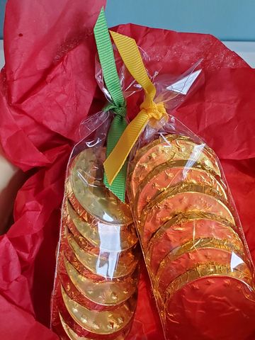 Two bags of gold-foil wrapped chocolate coins tied with colorful ribbons.
