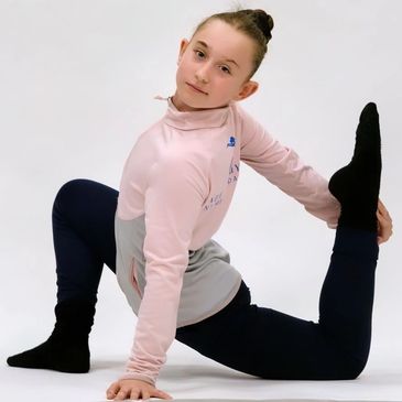 Young girl stretching in a yoga pose against a white background.