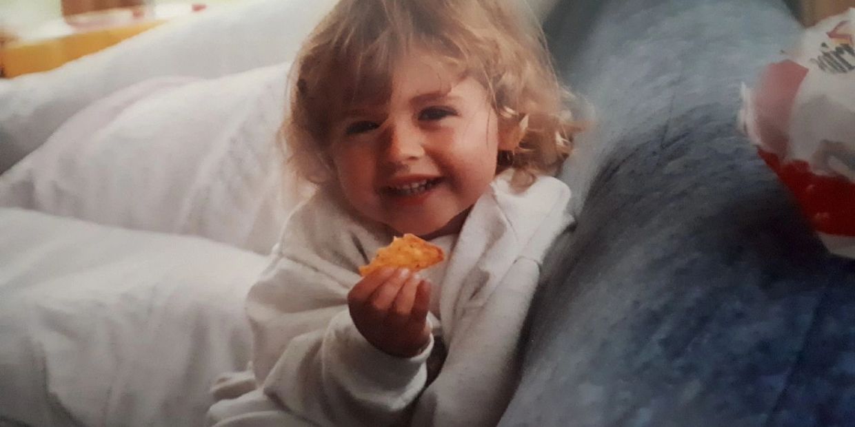 Un jeune enfant déguste joyeusement un Dorito, son visage illuminé par le plaisir.