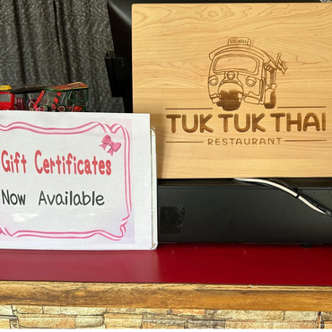 Gift certificates available at Tuk Tuk Thai Restaurant with tuk tuk model decoration.