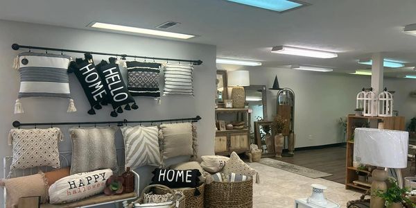 Cozy home decor store with pillows, baskets, and lamps in neutral tones.
