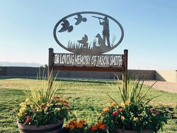 Memorial sign for Jason Smith with hunting scene.
