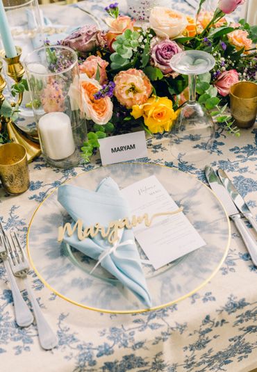 Elegant wedding table setting with floral centerpiece and personalized name card. 