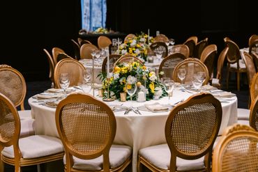 Elegant round tables with floral centerpieces and neatly arranged glassware and cutlery.