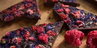 Dark chocolate bark decorated with freeze dried raspberry and blue pea flowers