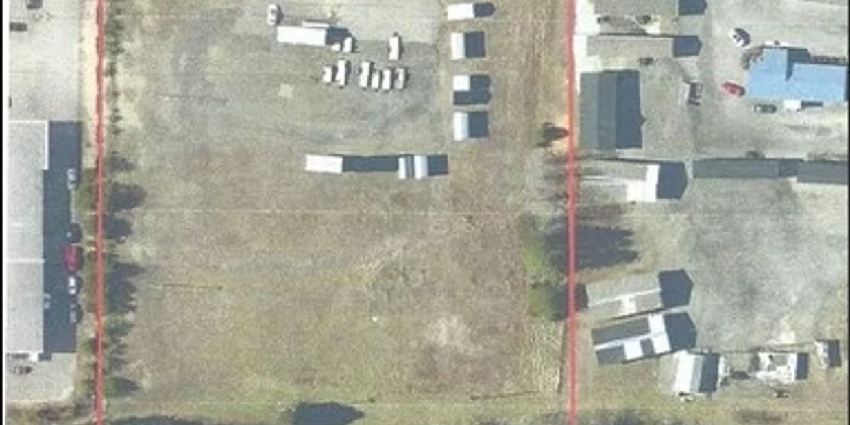 Aerial view of an industrial area with scattered containers and buildings.