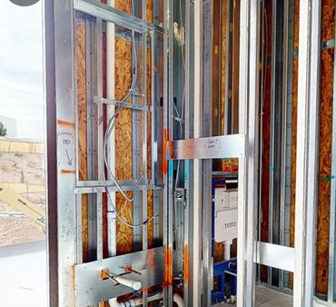 Exposed metal framing and plumbing during building construction.