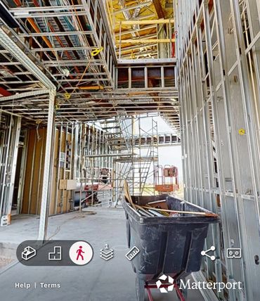 Construction site with metal framing and scaffolding inside a building.