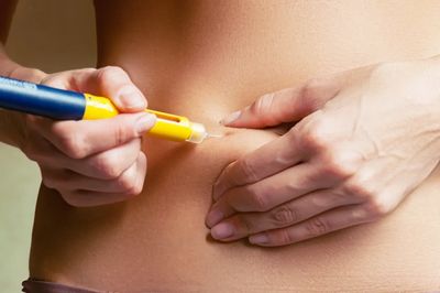 Patient injecting weight loss medication subcutaneously 