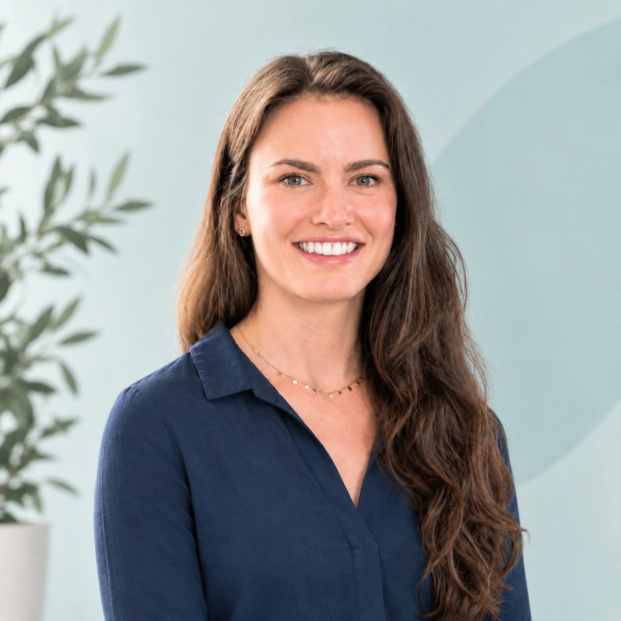Smiling woman with long hair and blue shirt.