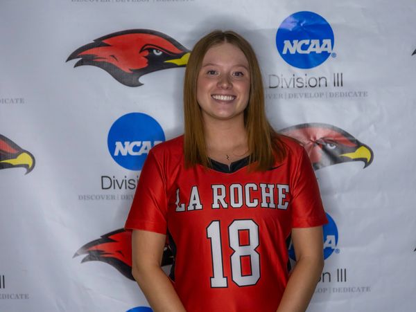 Smiling female athlete in red La Roche jersey with number 18.