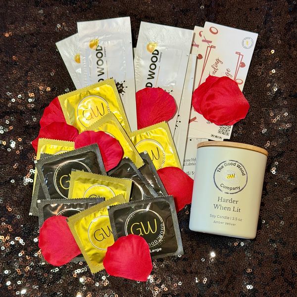 A mix of gold and black Good Wood condom packets - ultra thin and x-large with red rose petals 