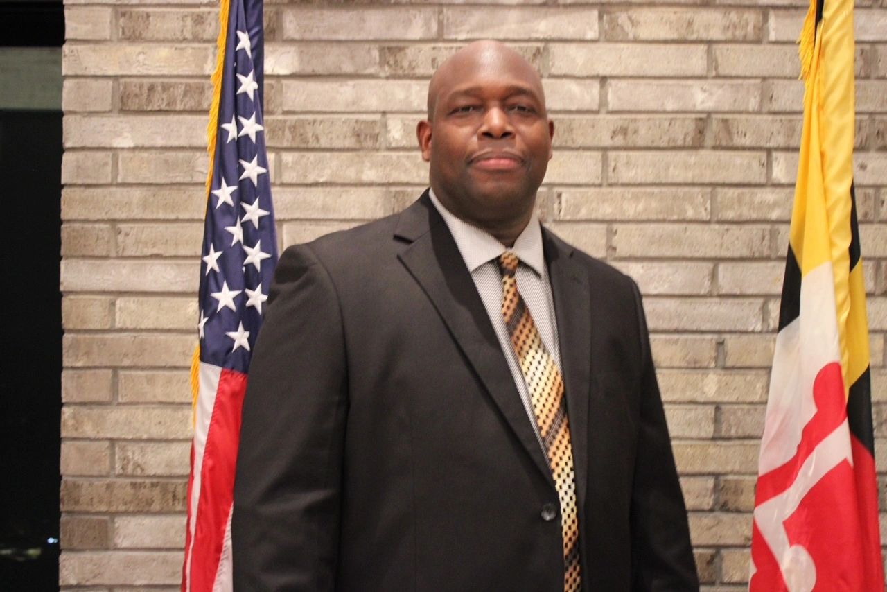 Stack of books next to pencils in a holder and a camera.