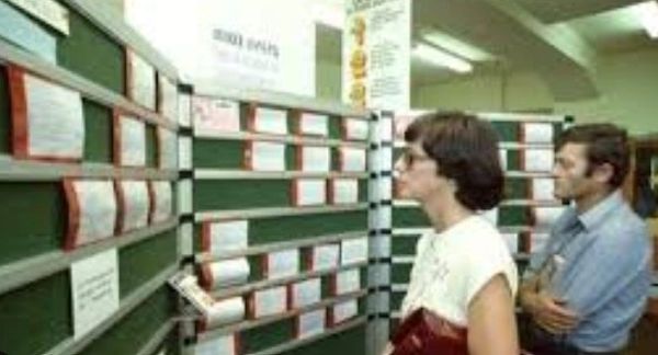 People looking at shelves filled with files or documents.