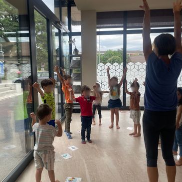 Children participating in a guided stretching activity indoors.