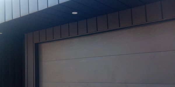 Modern dark gray garage door with sleek panel design.