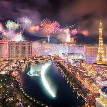 Fireworks light up the Las Vegas Strip with fountains and iconic buildings at night.