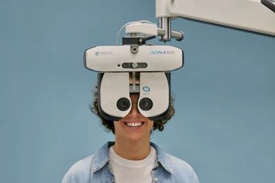 Person undergoing an eye exam with a phoropter device.