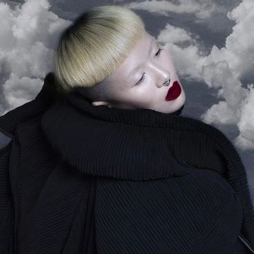 Person with platinum blonde hair and bold red lipstick.