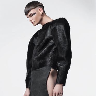 Model wearing a futuristic black outfit with unique texture and cut.