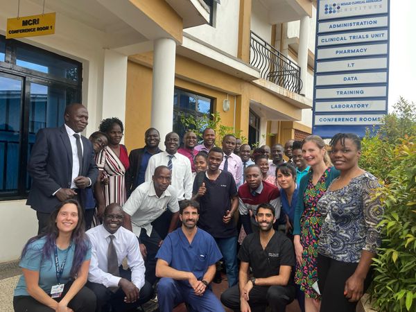 Group photo of diverse professionals outside a conference room.