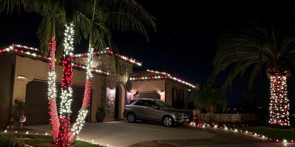 Christmas lights on a home and palm trees